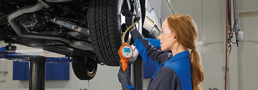 A Subaru technician checking tire pressure. | Crown Subaru of Wheeling in Triadelphia WV