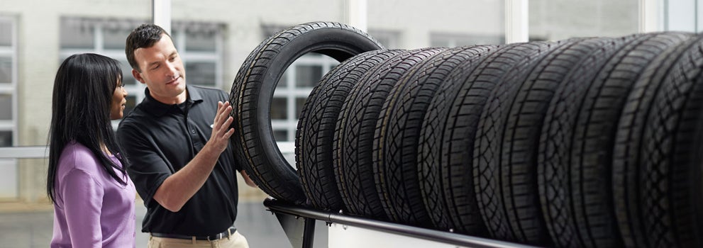 Subaru service representative showing customer a tire. | Crown Subaru of Wheeling in Triadelphia WV